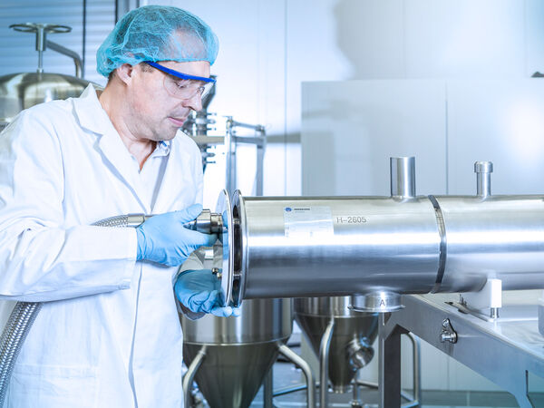 Ein Arbeiter führt eine Werksabnahme an einer Maschine durch.