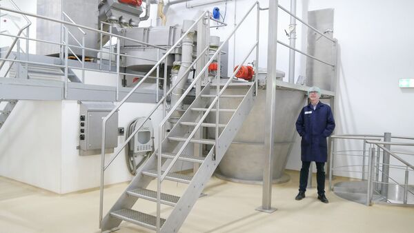 Mann steht neben einem Hosokawa Alpine Mischer