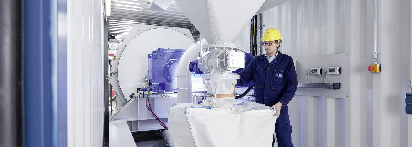 Mann bedient eine Hosokawa Alpine Maschine